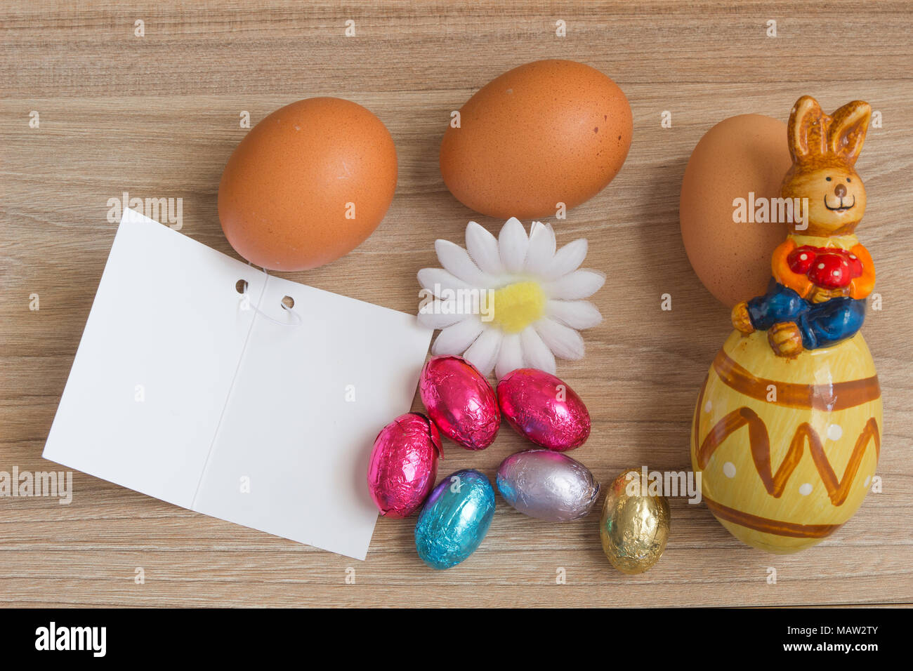 Concept de Pâques. Joyeuses Pâques journée avec des œufs, carte de vœux, fleurs et céramique lapin sur table en bois avec l'exemplaire de l'espace. Banque D'Images Concept de Pâques. Joyeuses Pâques journée avec des œufs, carte de vœux, fleurs et céramique lapin sur table en bois avec l'exemplaire de l'espace. Banque D'Images