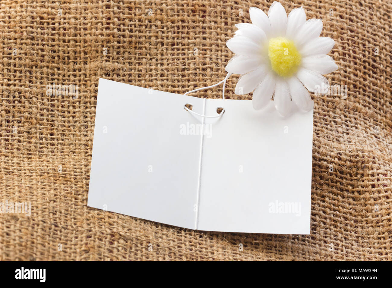 Carte vide blanc sur marron sacs avec fond de fleurs blanches pour remplacer votre conception. Banque D'Images
