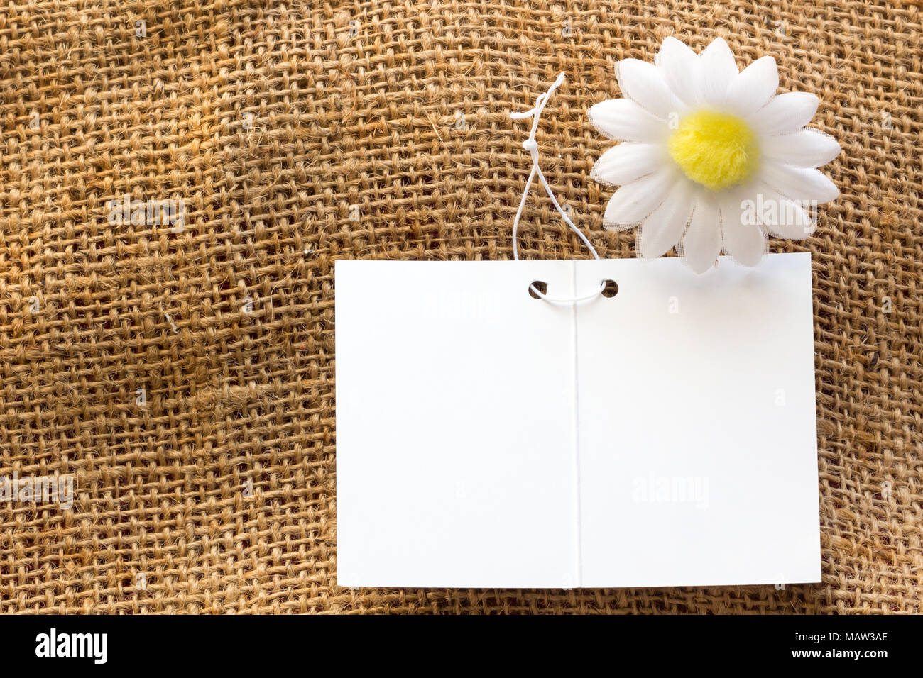 Carte vide blanc sur marron sacs avec fond de fleurs blanches pour remplacer votre conception. Banque D'Images Carte vide blanc sur marron sacs avec fond de fleurs blanches pour remplacer votre conception. Banque D'Images