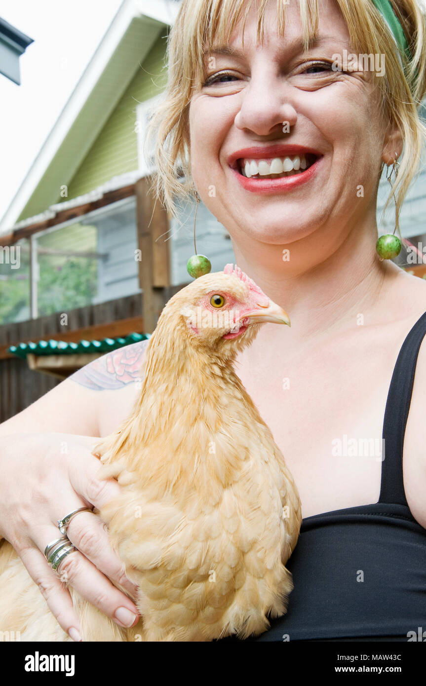 Une femme tenant son animal buff orpington poulets qu'elle utilise pour pondre des oeufs pour sa famille à Portland, Oregon. Banque D'Images