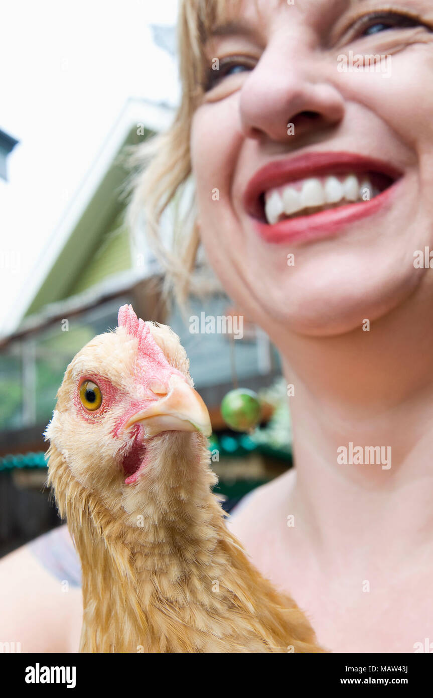 Une femme tenant un buff-orpington poulets dans son jardin à Portland, Oregon. Banque D'Images