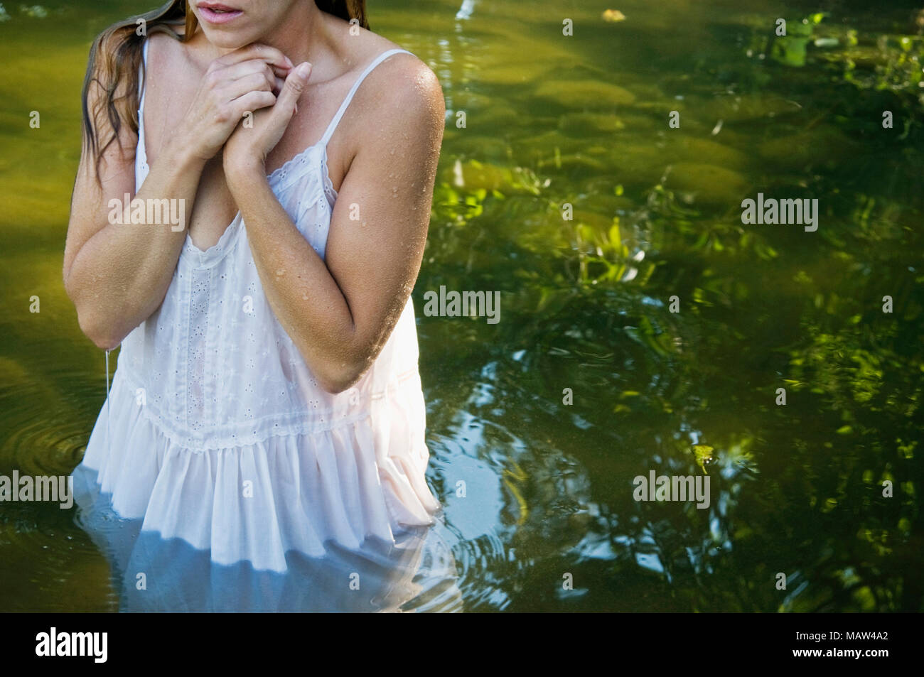 Une femme humide avec Poule debout dans l'eau. Banque D'Images