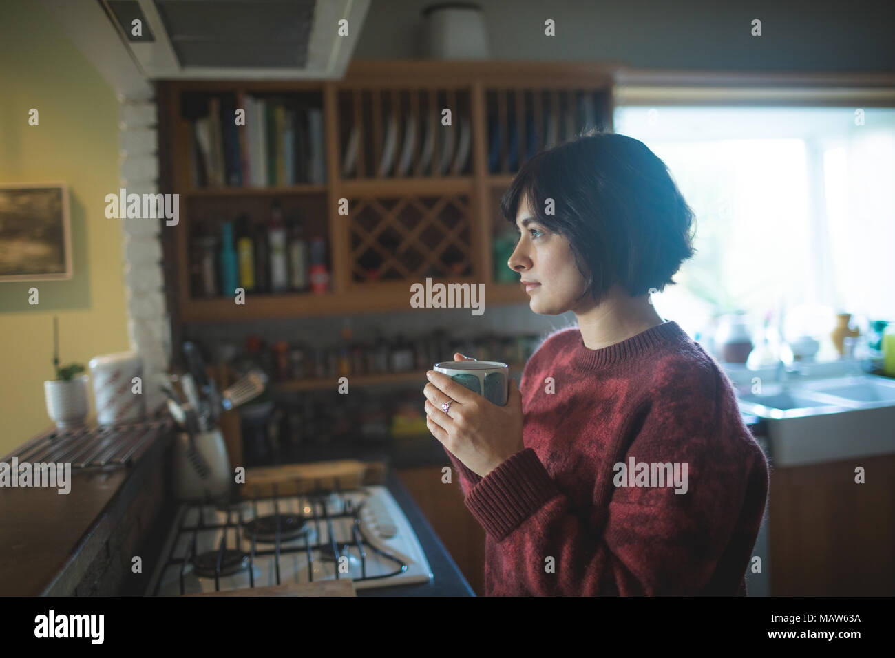 Woman having coffee in cuisine à la maison Banque D'Images