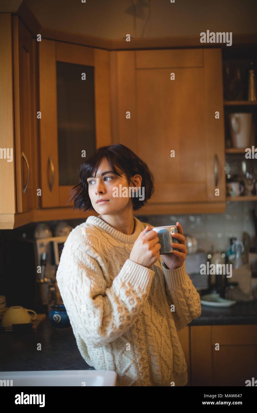 Woman having coffee in cuisine à la maison Banque D'Images