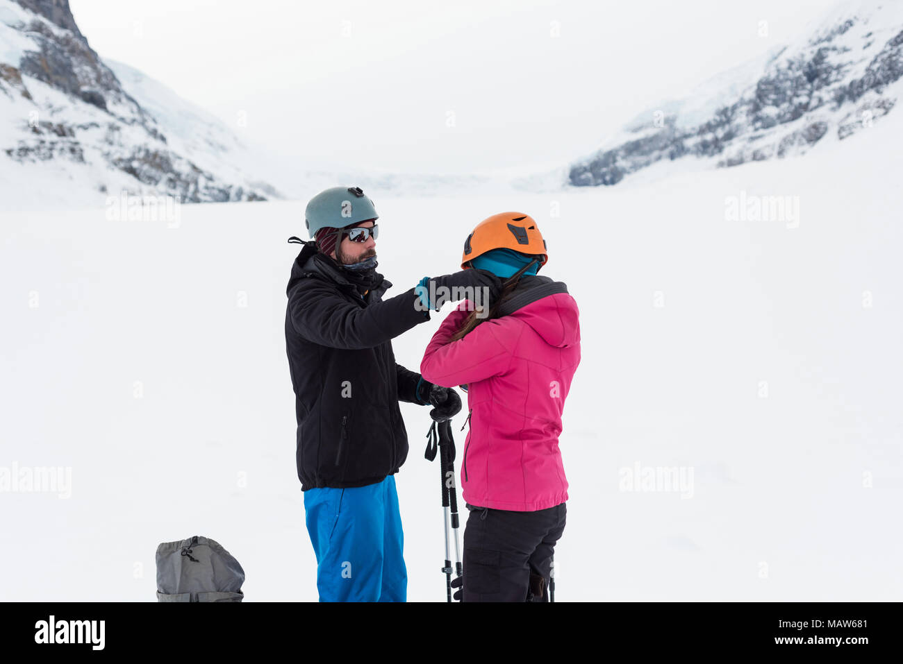 Couple wearing helmet sur une montagne couverte de neige Banque D'Images