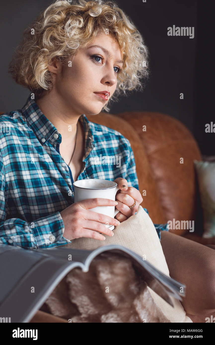 Woman having coffee dans la salle de séjour à la maison Banque D'Images