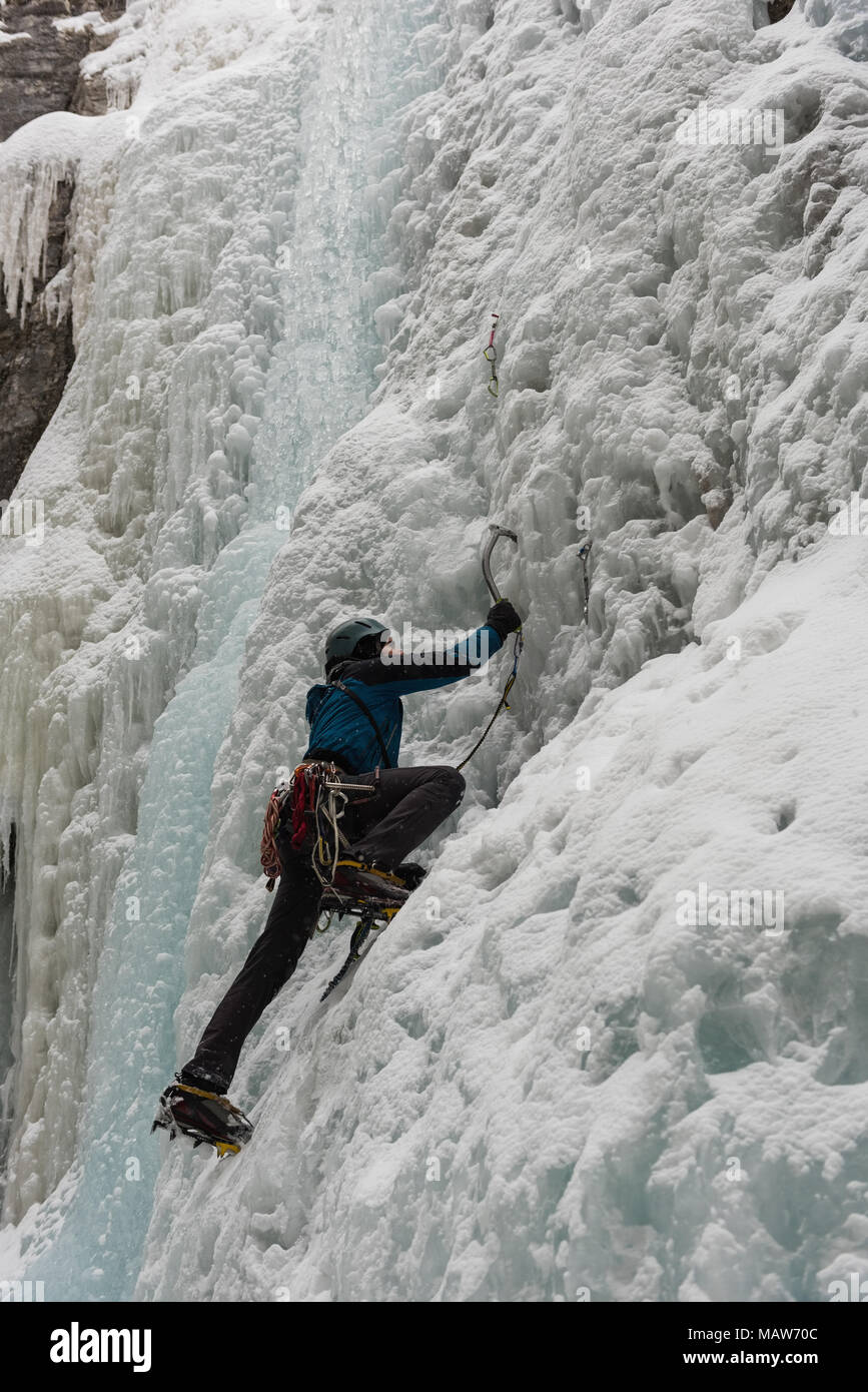 Male rock climber climbing ice mountain Banque D'Images