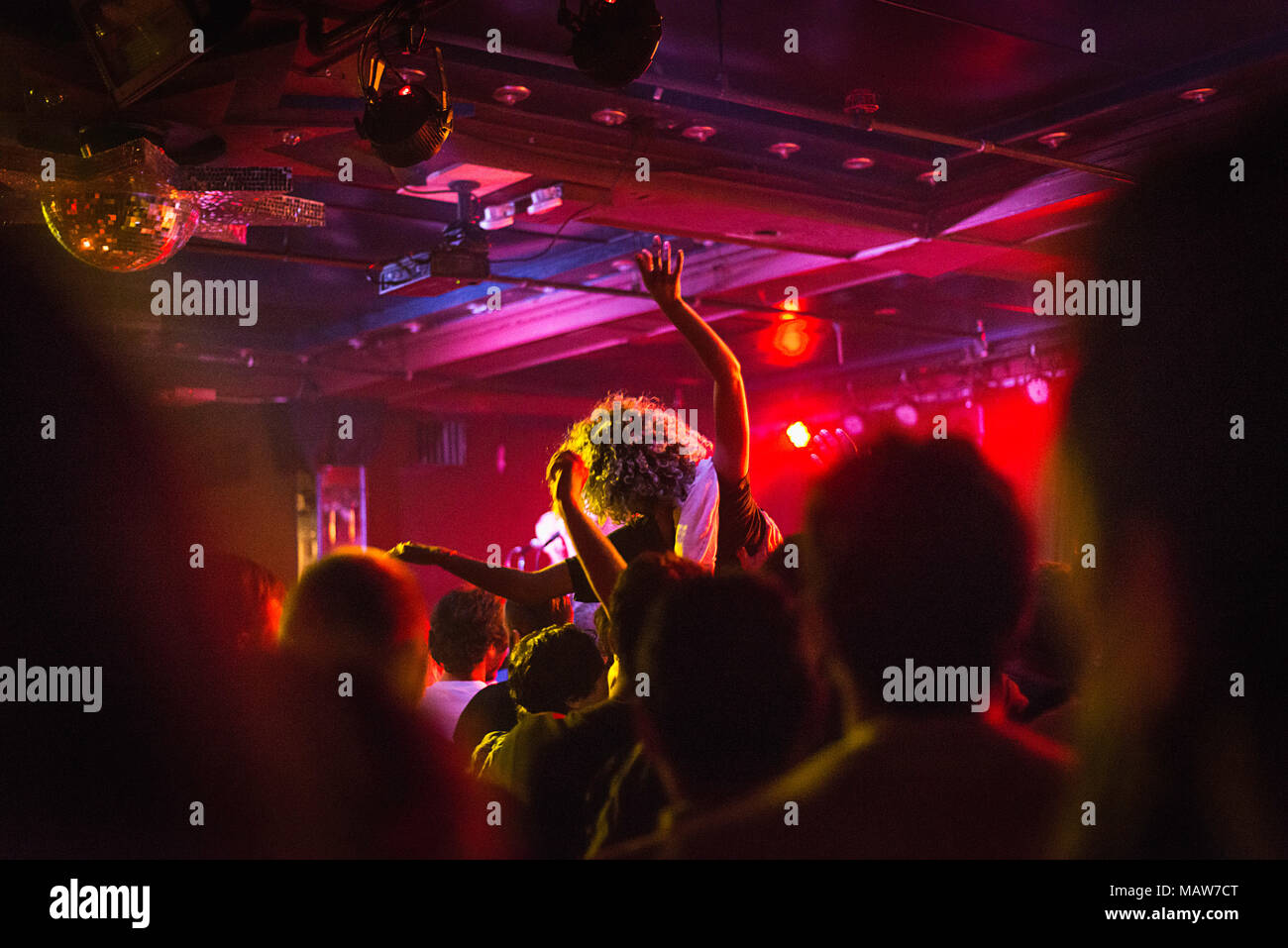Une jeune femme crowd surfing. Banque D'Images