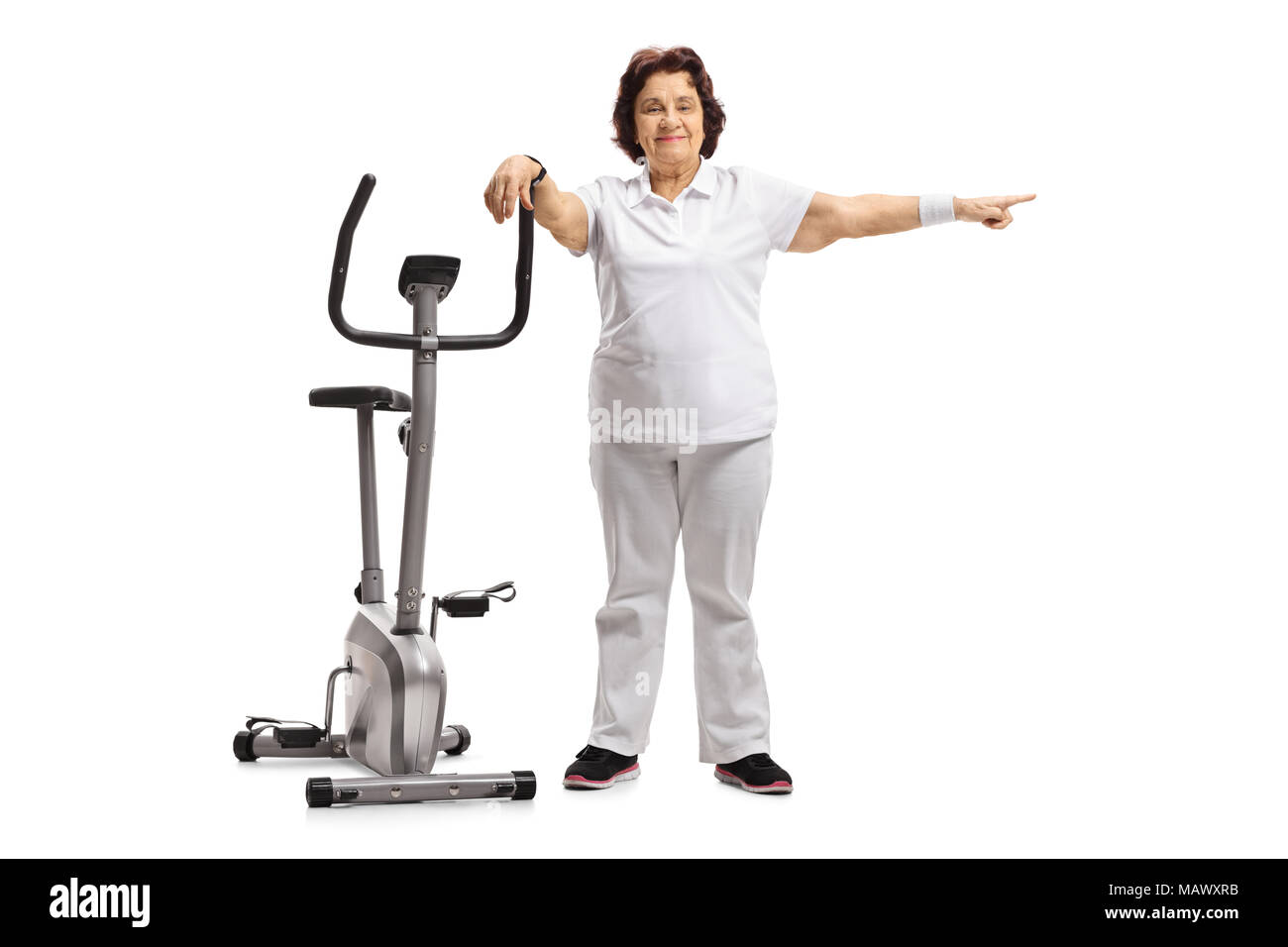 Portrait d'une femme âgée s'appuyant sur un vélo d'exercice et de pointage isolé sur fond blanc Banque D'Images