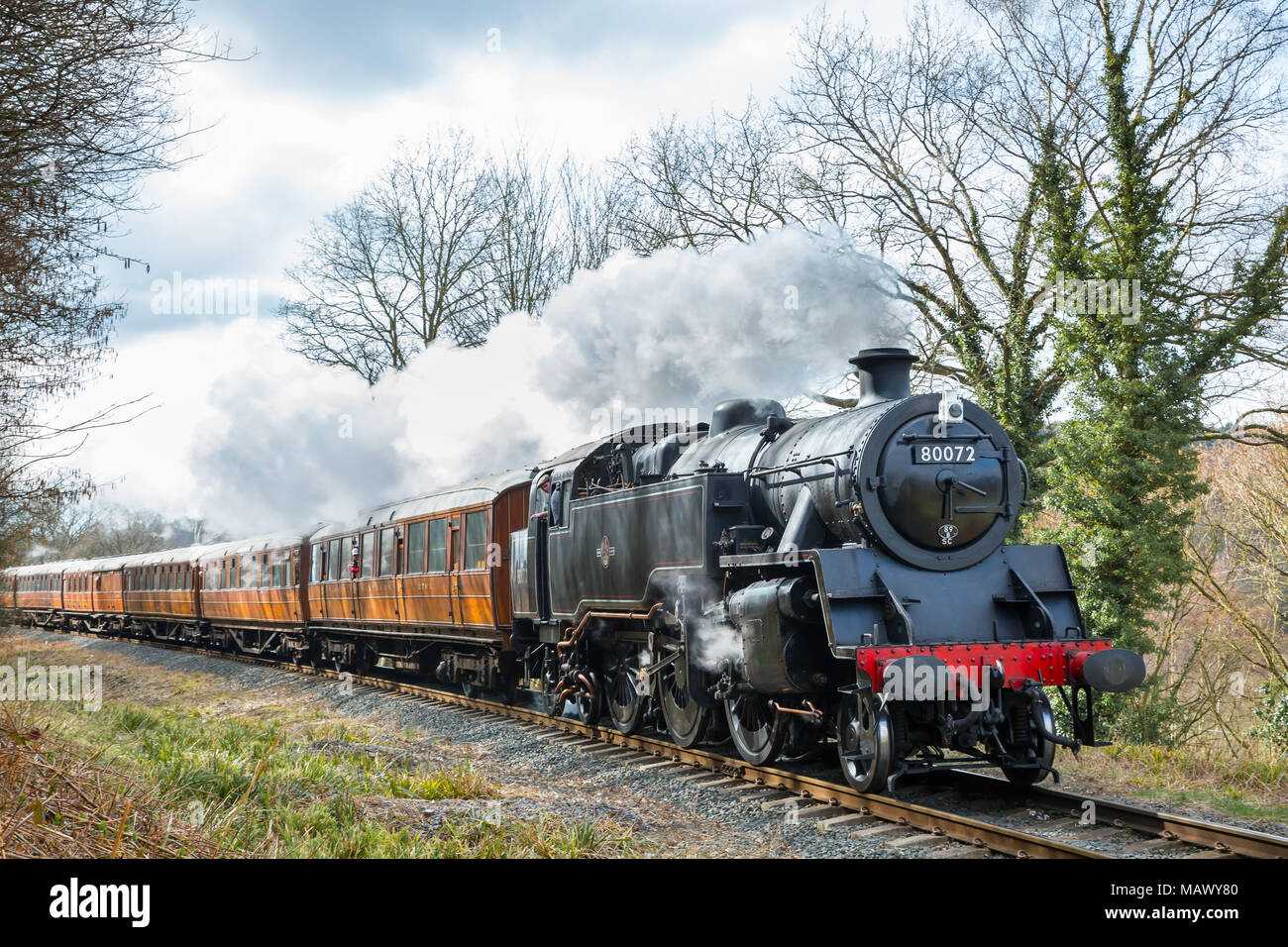 Vue avant close up of vintage UK isolé sur train à vapeur de la ligne de chemin de fer du patrimoine SVR que quelques bouffées, en passant par les régions rurales, campagne dans soleil du printemps. Banque D'Images