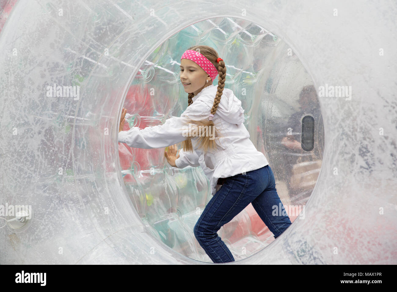 Teen girl heureusement s'exécute dans un grand cylindre gonflable zorb- Banque D'Images
