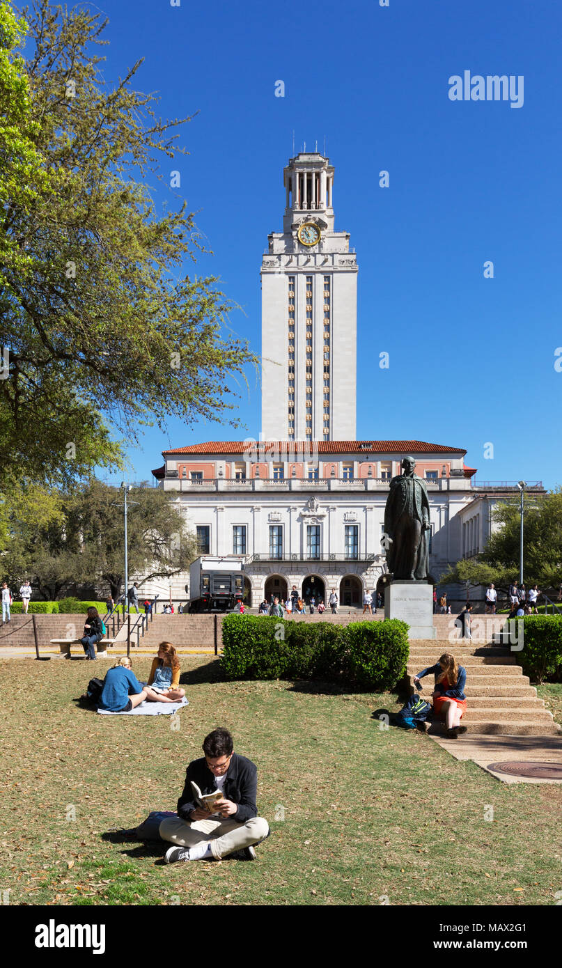 Les élèves de la lecture sur l'herbe au soleil du printemps, l'université du Texas à Austin, Austin, Texas USA Banque D'Images