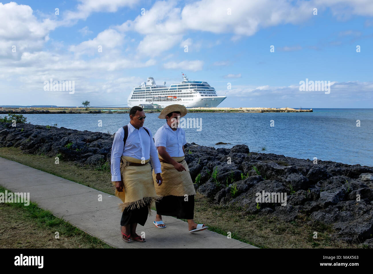 Les hommes de marcher au bord de l'eau dans Nuku'alofa, Tonga sur l'île de Tongatapu. Nukuʻalofa est la capitale du Royaume des Tonga Banque D'Images