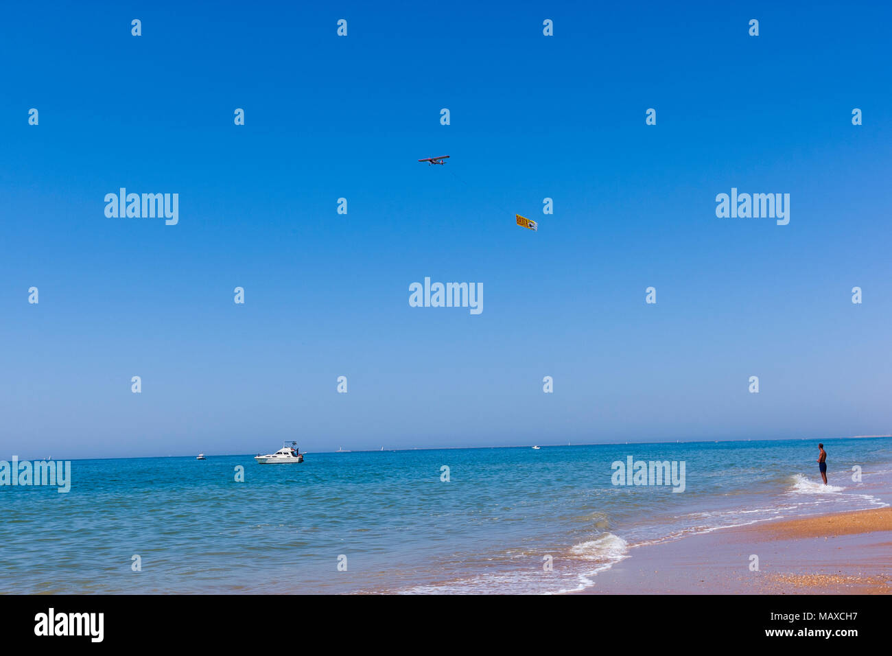 Place l'observation d'une publicité plane flying en Parador Mazagon beach, province de Huelva, Andalousie, Espagne Banque D'Images