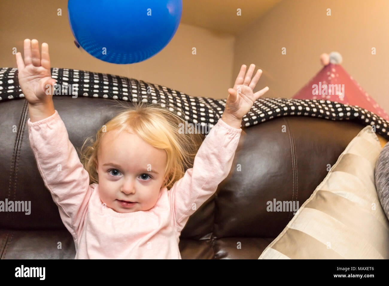 Les bras levés de l'enfant jouant avec balloon Banque D'Images