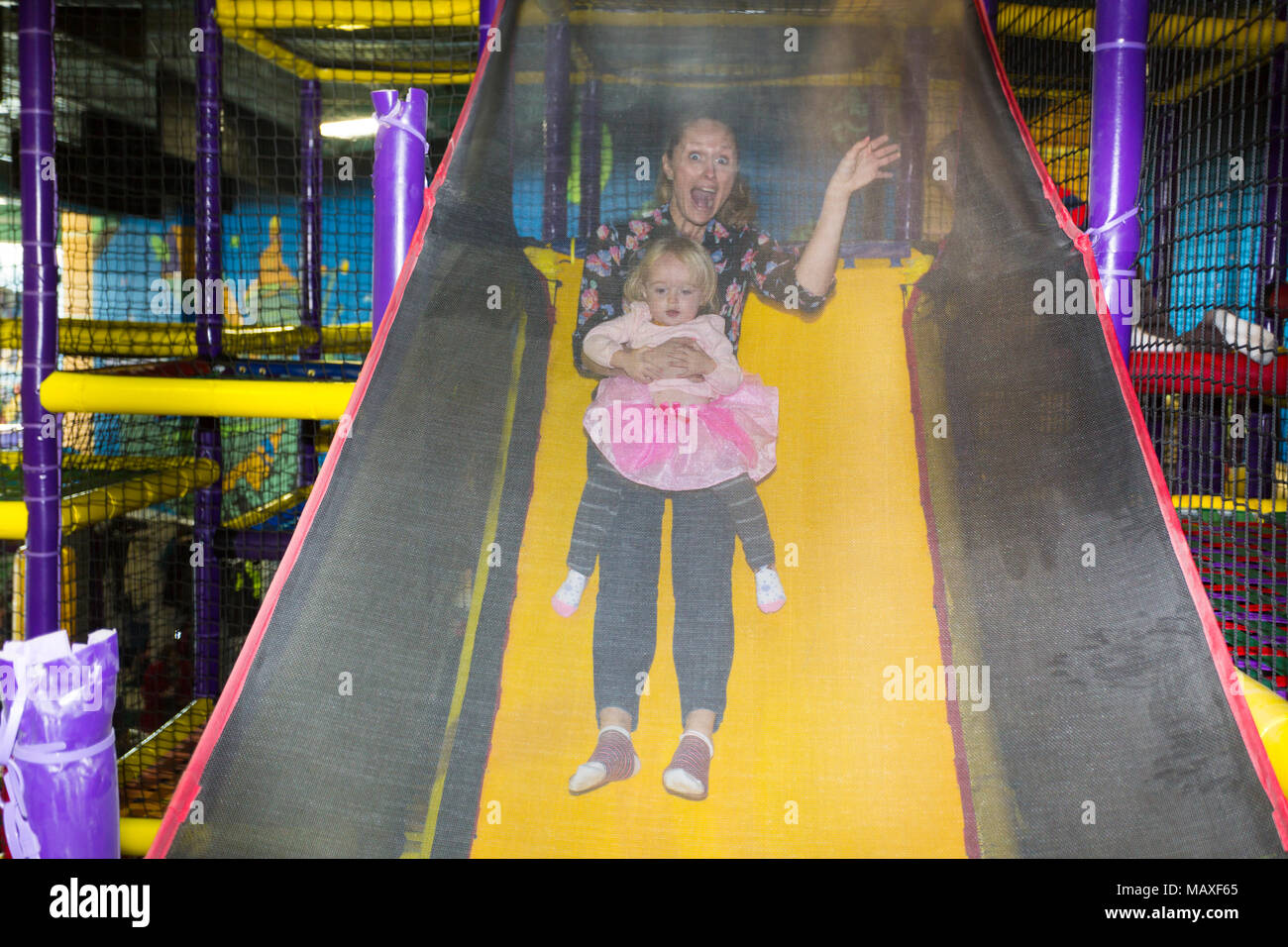 Une mère de famille sur la diapositive à l'aire de jeux couverte, Ottawa, Ontario, Canada Banque D'Images