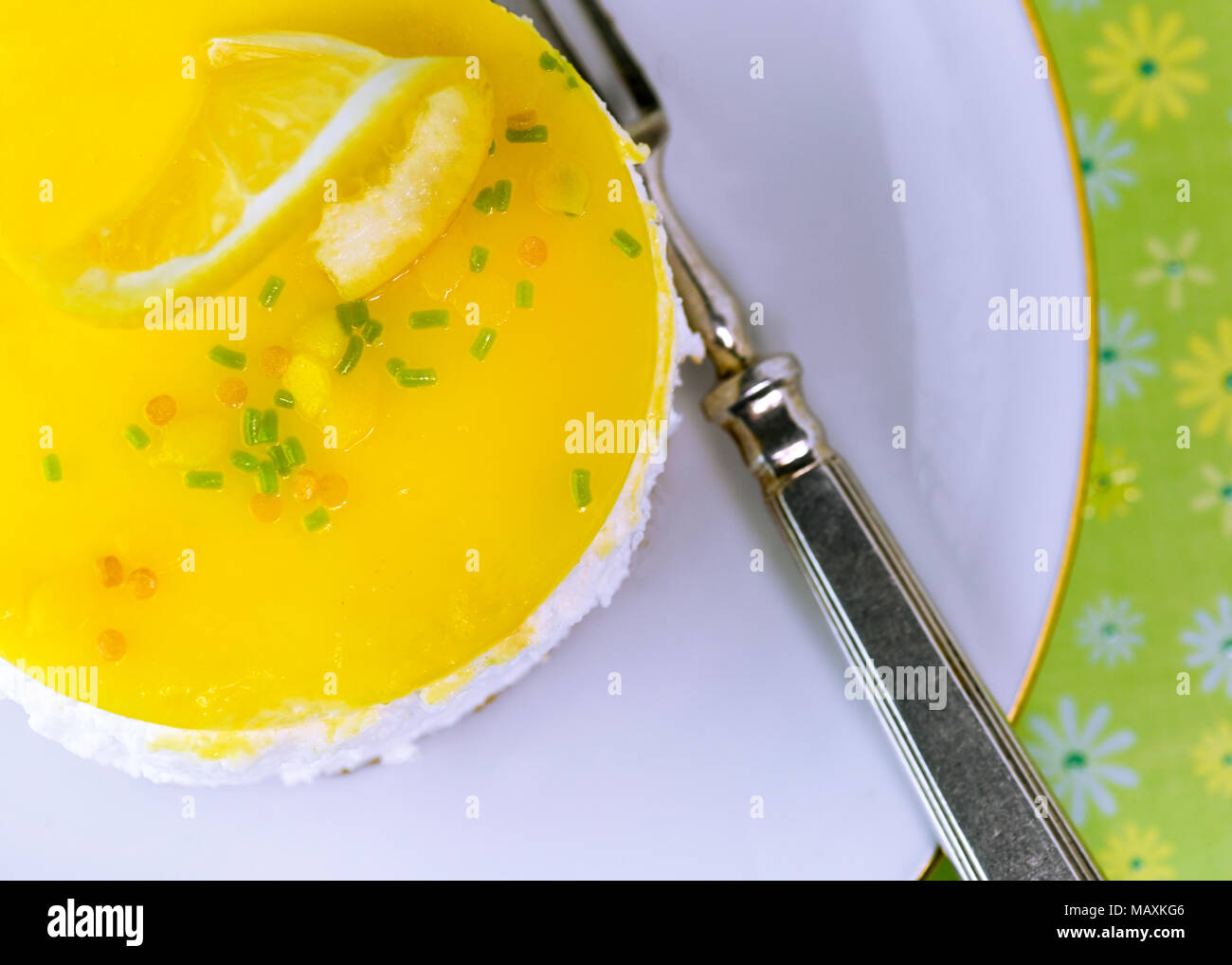 Sur la tête de droit de mousse au citron gâteau au fromage sur une plaque blanche avec une couleur de fond vert Banque D'Images