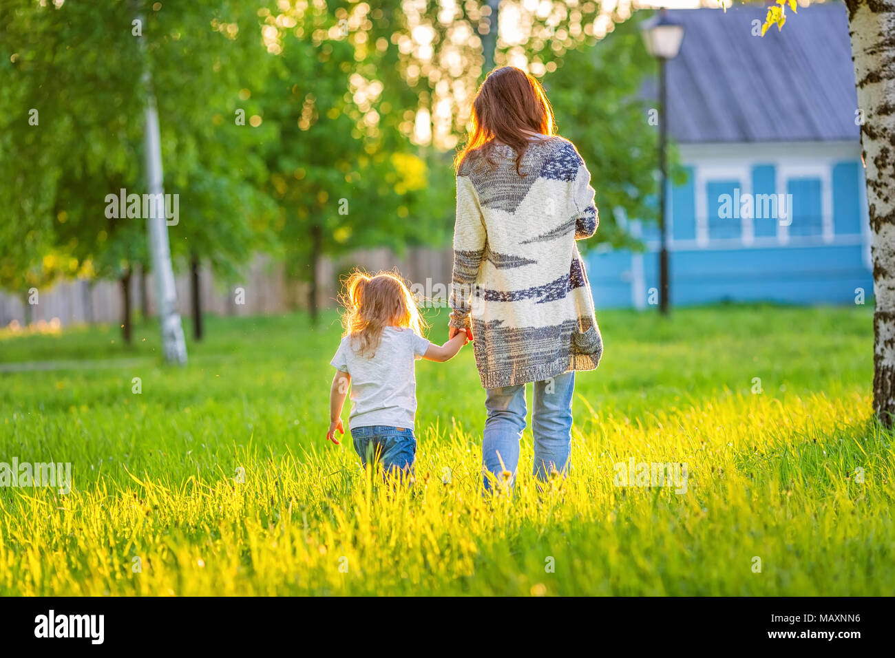 Mère et fille marcher au printemps sunny park Banque D'Images