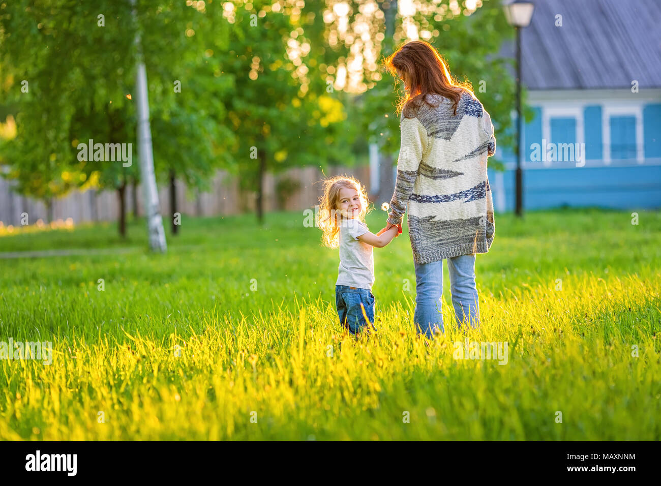 Mère et fille marcher au printemps sunny park Banque D'Images