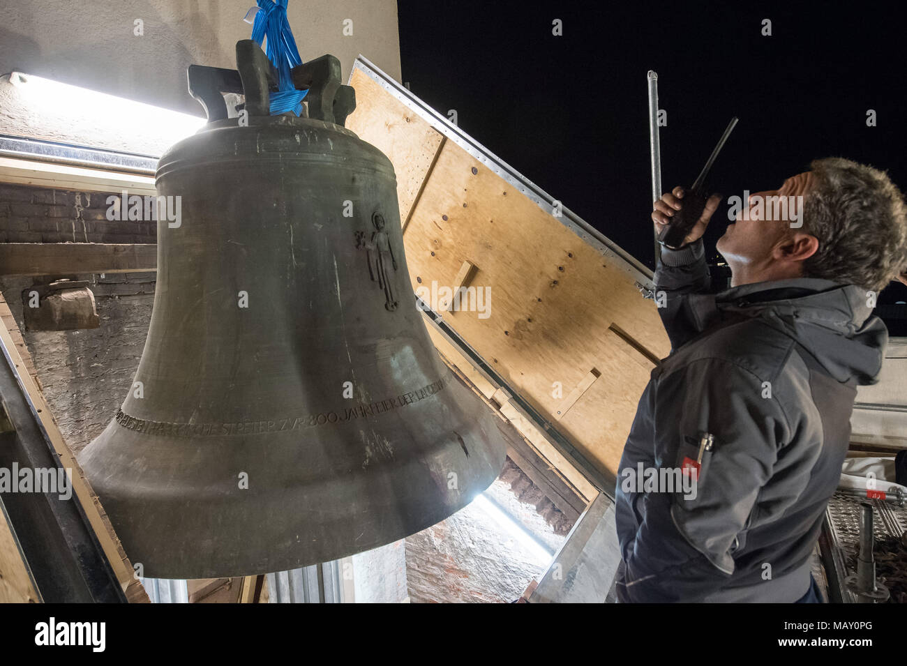 04 avril 2018, Allemagne, Munich : Une grue supprime un 7-ton anniversaire bell, de la 'Changer' Peter church tower pour travaux de réparation. Roland Maurer surveils la suppression. La cloche dans Munich, plus ancienne église catholique de Saint Pierre mesure environ 2.2m x 2.0m et est l'un des plus grands et plus cloches sonores en Bavière. Photo : Peter Kneffel/dpa Banque D'Images