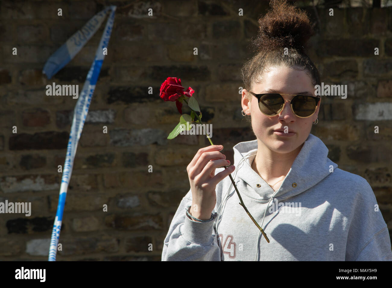 London UK 5 avril 2018 une femme tient une rose à la scène où Israël Ogunsola âgé de 20 ans, s'est effondrée après avoir été mortellement poignardé la nuit dernière près de Link Street, Hackney. Credit : Thabo Jaiyesimi/Alamy Live News Banque D'Images