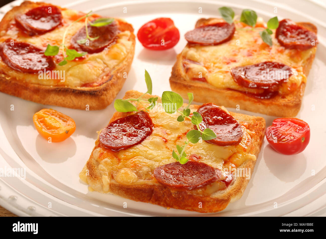 Toasts frais avec fromage fondu et chorizo on white plate Banque D'Images