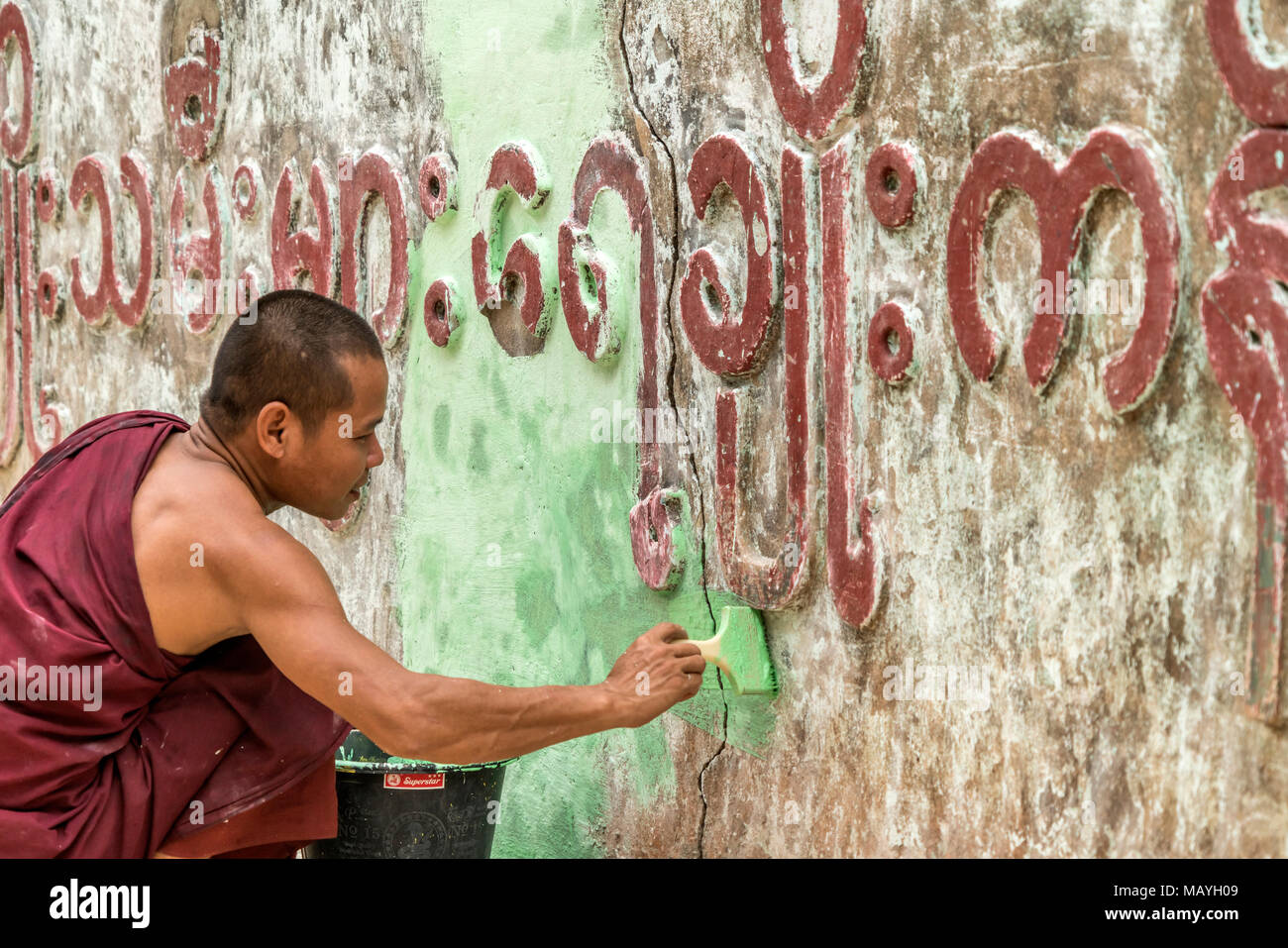 Junge Mönche beim Anstreichen einer Mauer, Hpa-an, Myanmar, Asien | jeunes moines peindre un mur, Hpa-an, au Myanmar, en Asie Banque D'Images