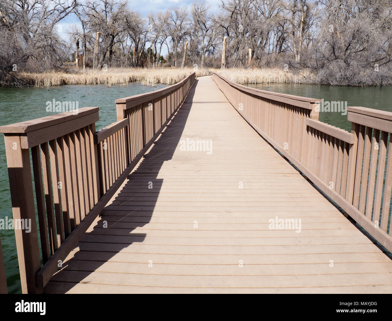 Une longue promenade, en matériau composite, s'étend sur plus de l'eau. Banque D'Images