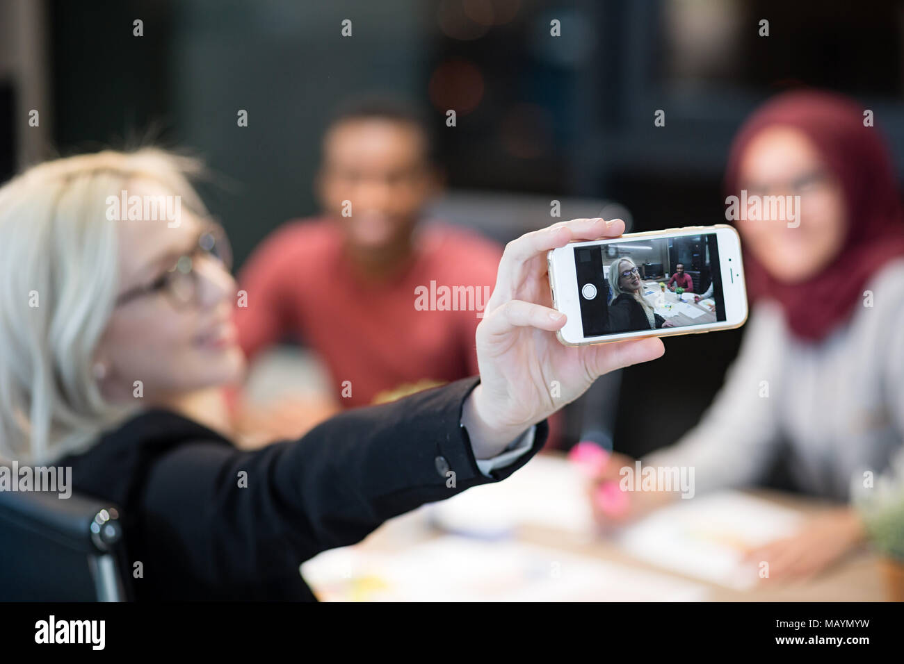Groupe de trois collègues de travail joyeuse taking self portrait dans le bureau de conception moderne Banque D'Images