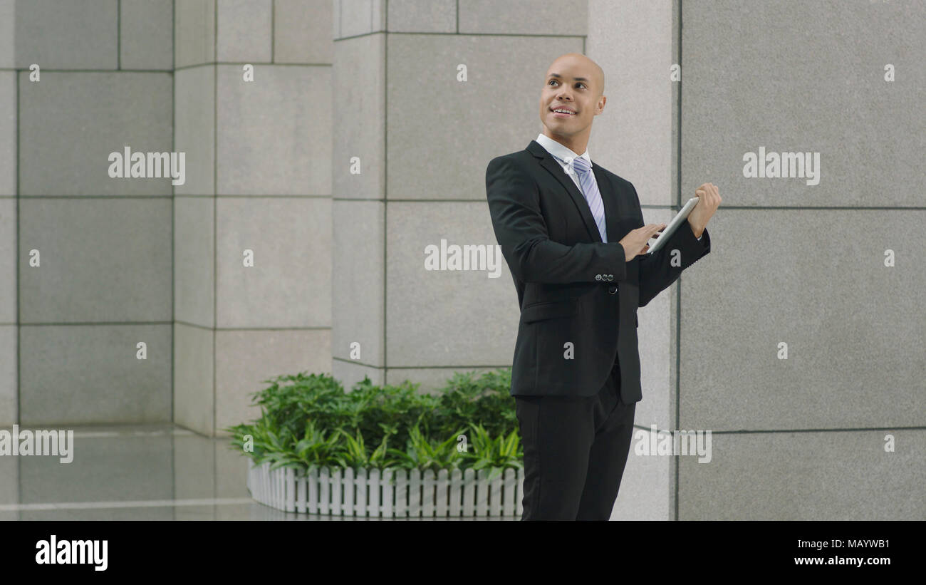Cadre d'entreprise latino holding digital tablet à up smiling. Banque D'Images
