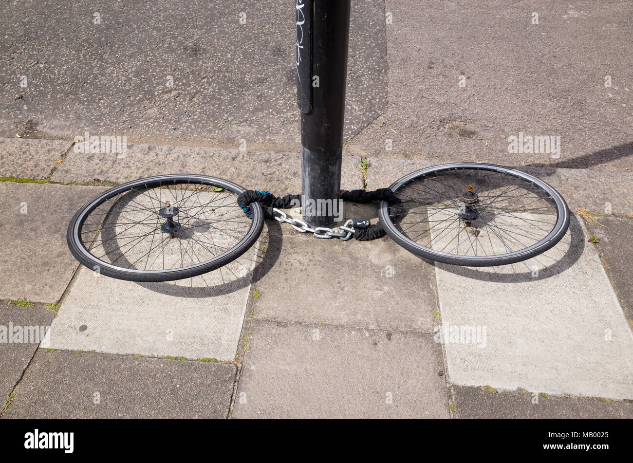 Vélo volé avec roues à gauche enchaîné à un poteau, au Royaume-Uni, Londres Banque D'Images