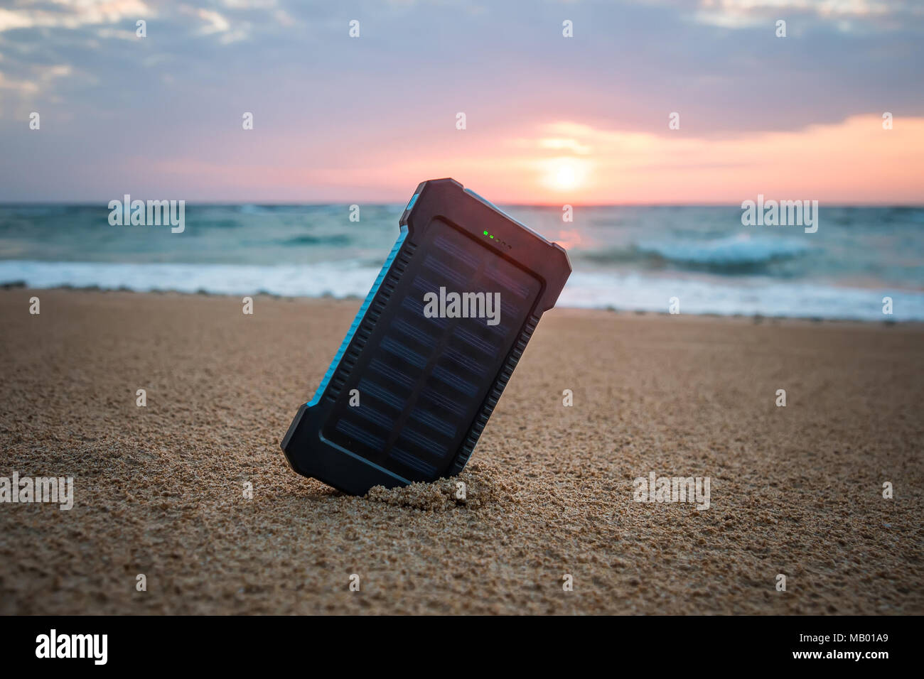 Petit panneau solaire portable près de l'océan Atlantique. Powerbank pour charger les téléphones portables et autres périphériques via USB. Batterie solaire au soleil sur la Banque D'Images