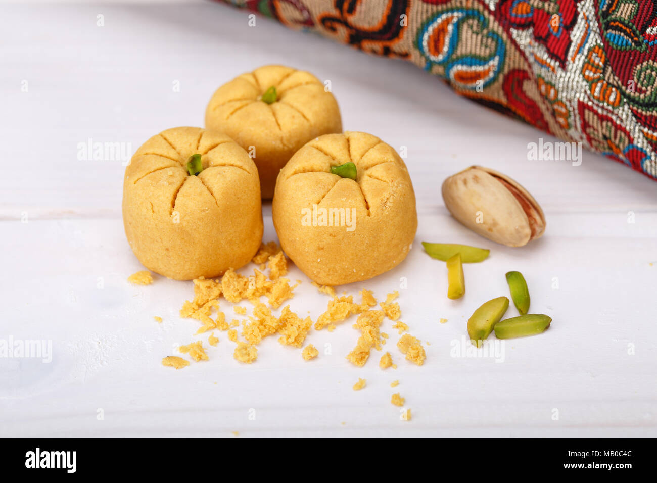 Le pois chiche de forme ronde des pâtisseries Cookies farine de gramme et la pistache iranienne traditionnelle des bonbons : Nokhodchi gros plan sur un fond de bois Banque D'Images