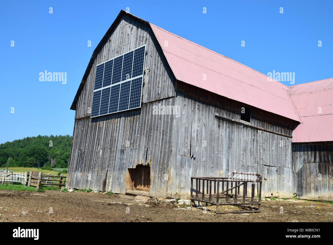 Une ancienne grange en bois avec panneaux solaires. Banque D'Images