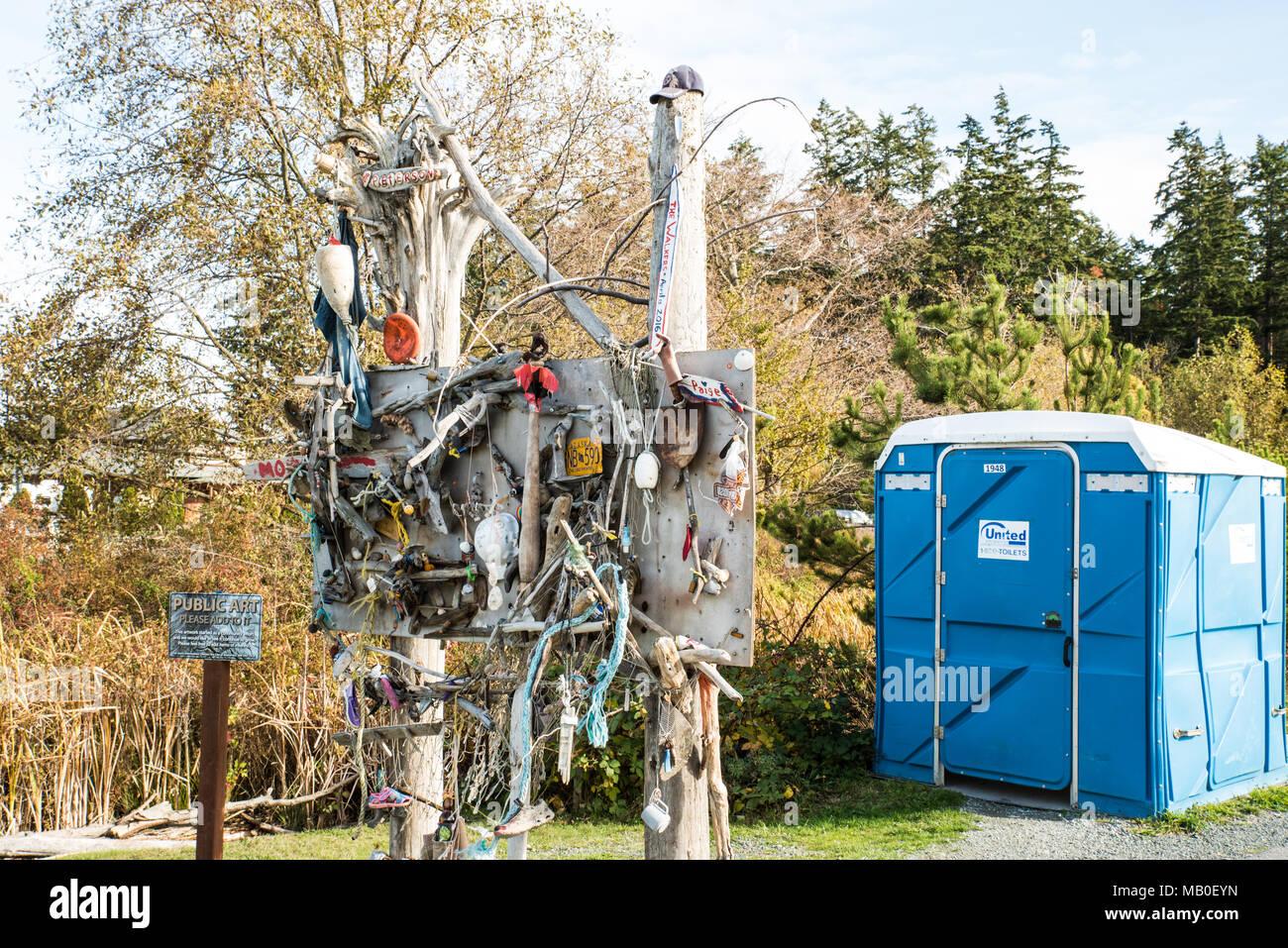 L'art public et de toilettes bleu-un conseil d'art public et d'un WC bleu sont disponibles pour l'admiration ou l'utilisation près de la Thompson Trail à Anacortes. Banque D'Images