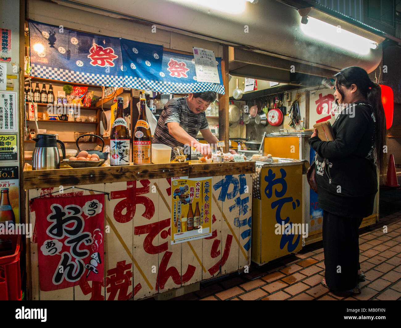 Femme à l'achat d'aliments d'une food, night street, Beppu, Japon, Kyushu Banque D'Images