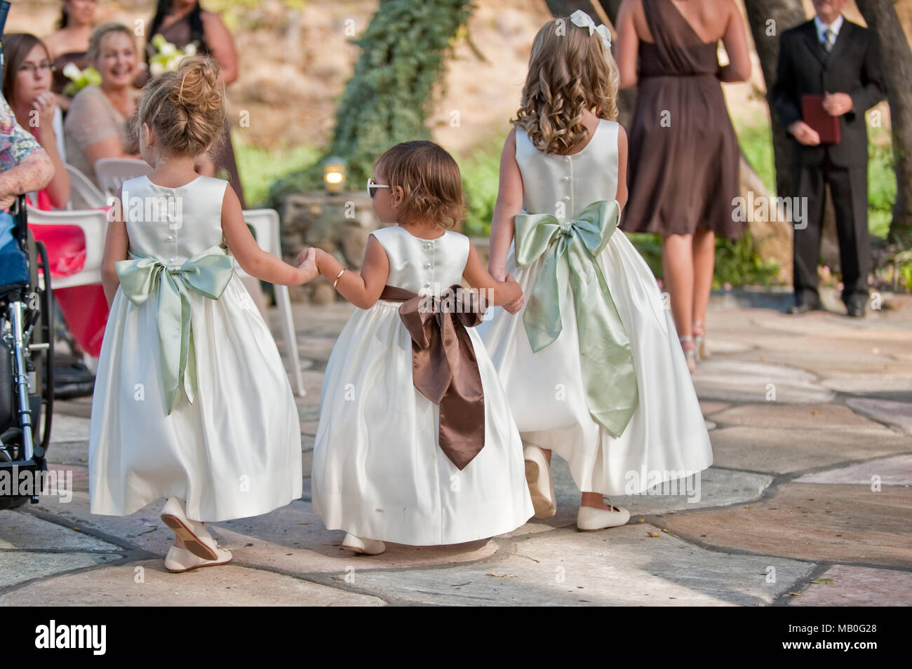 Trois petites filles mignonnes holding hands l'allée à un mariage en plein air à la California Banque D'Images