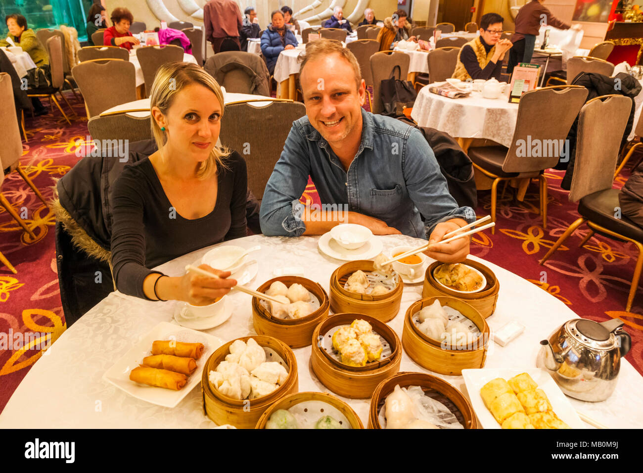 La Chine, Hong Kong, Tourist Couple Eating Dim Sum Banque D'Images