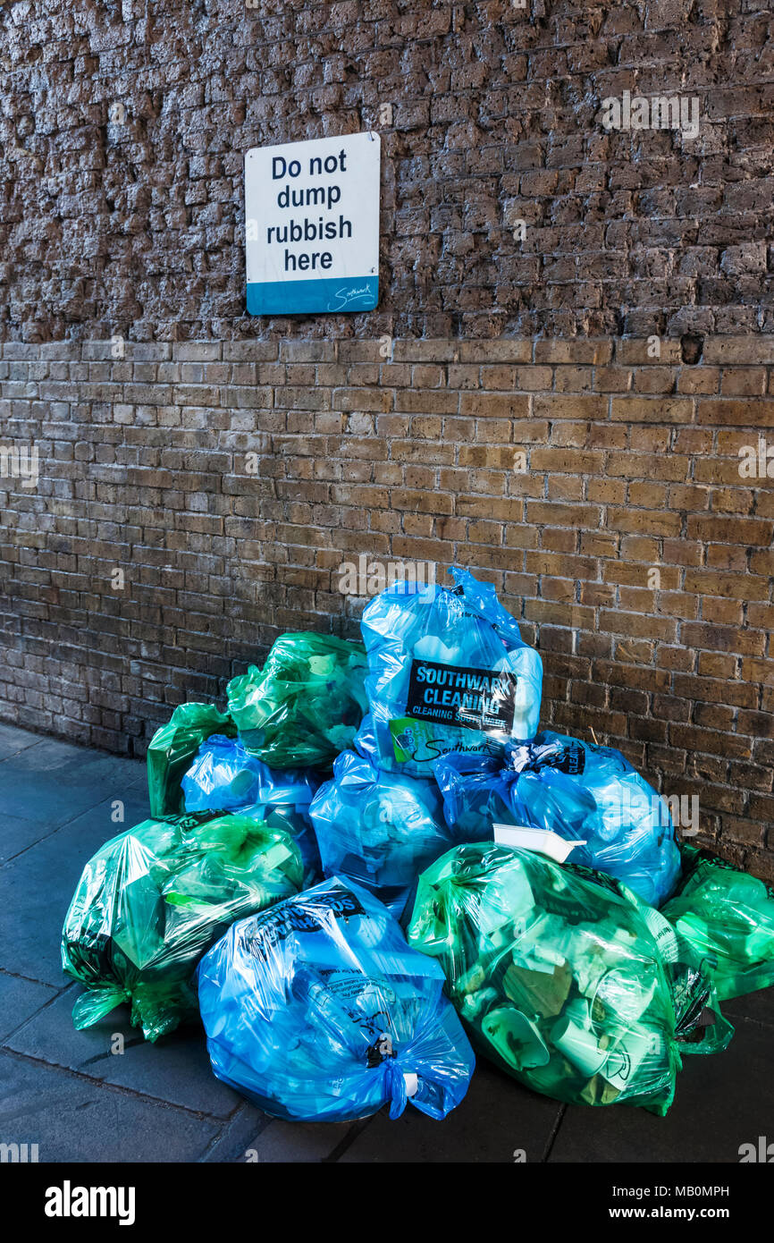 L'Angleterre, Londres, Southwark, de sacs à déchets en attente de collecte dans l'avant de signer le dumping pas de déchets Banque D'Images