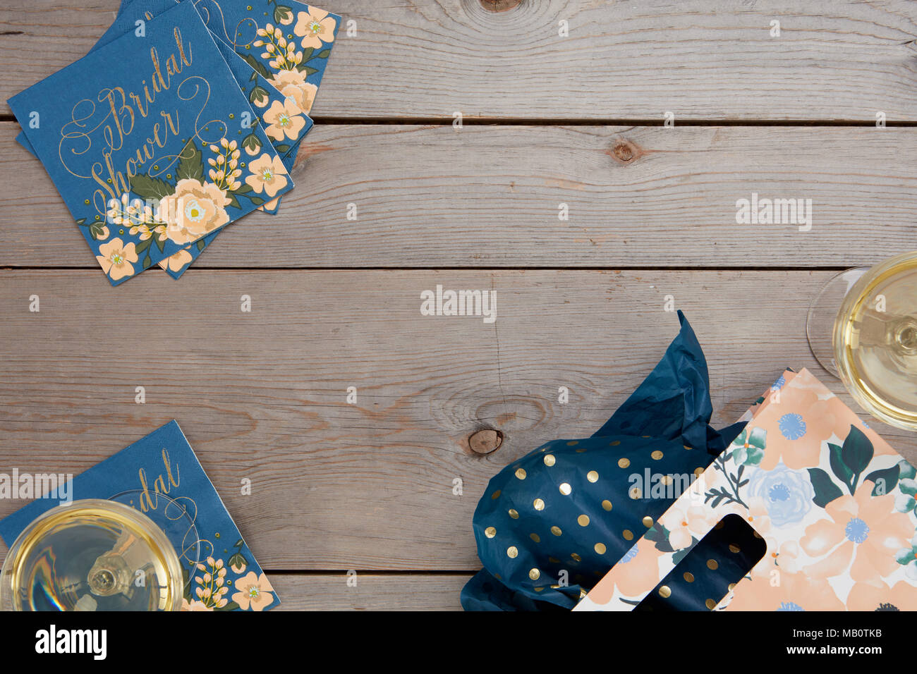 Floral bleu douche nuptiale rustique avec des décorations de table en verre de vin et un sac-cadeau sur fond de bois. Banque D'Images