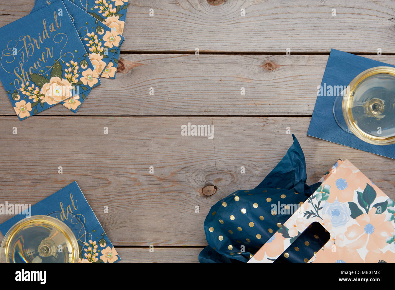 Floral bleu douche nuptiale rustique avec des décorations de table en verre de vin et un sac-cadeau sur fond de bois. Banque D'Images