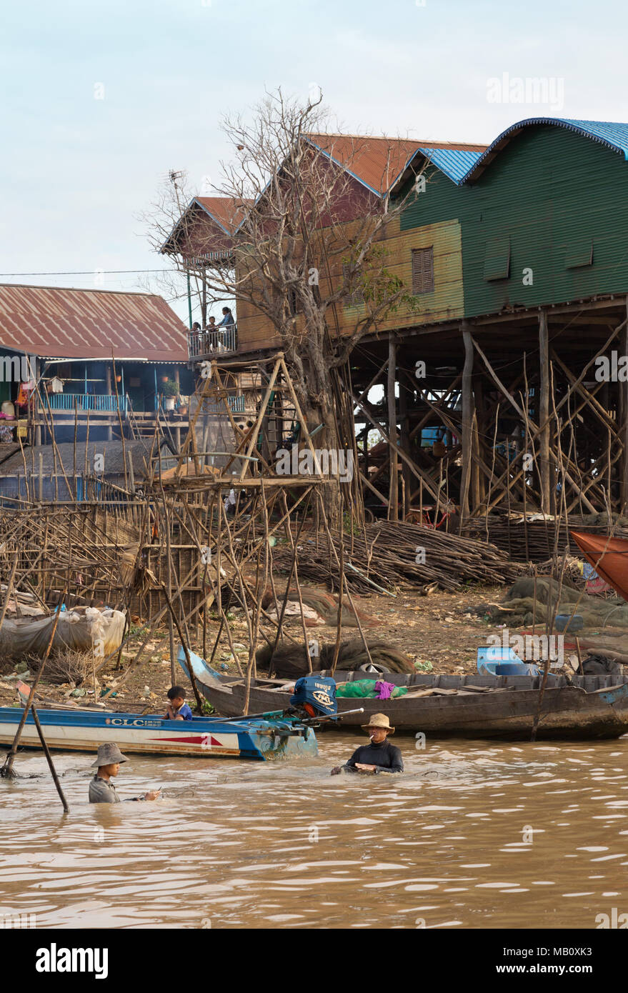 Pêcheur travaillant sur leurs filets dans l'eau à un village sur pilotis, Tonle Sap lac intérieur, Kampong Khleang, Cambodge, Asie Banque D'Images