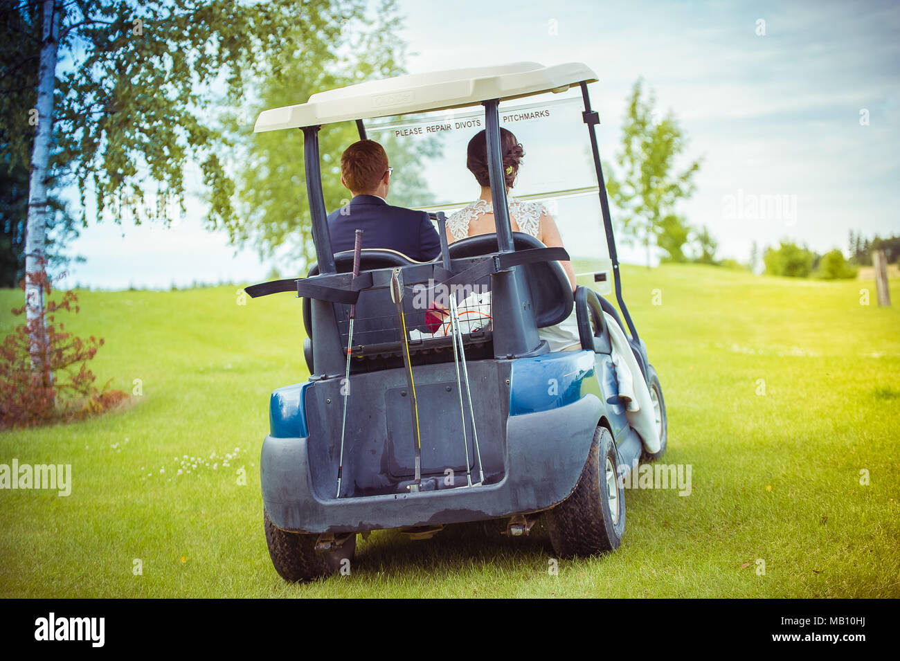 Couple de mariés dans une voiturette de golf Banque D'Images