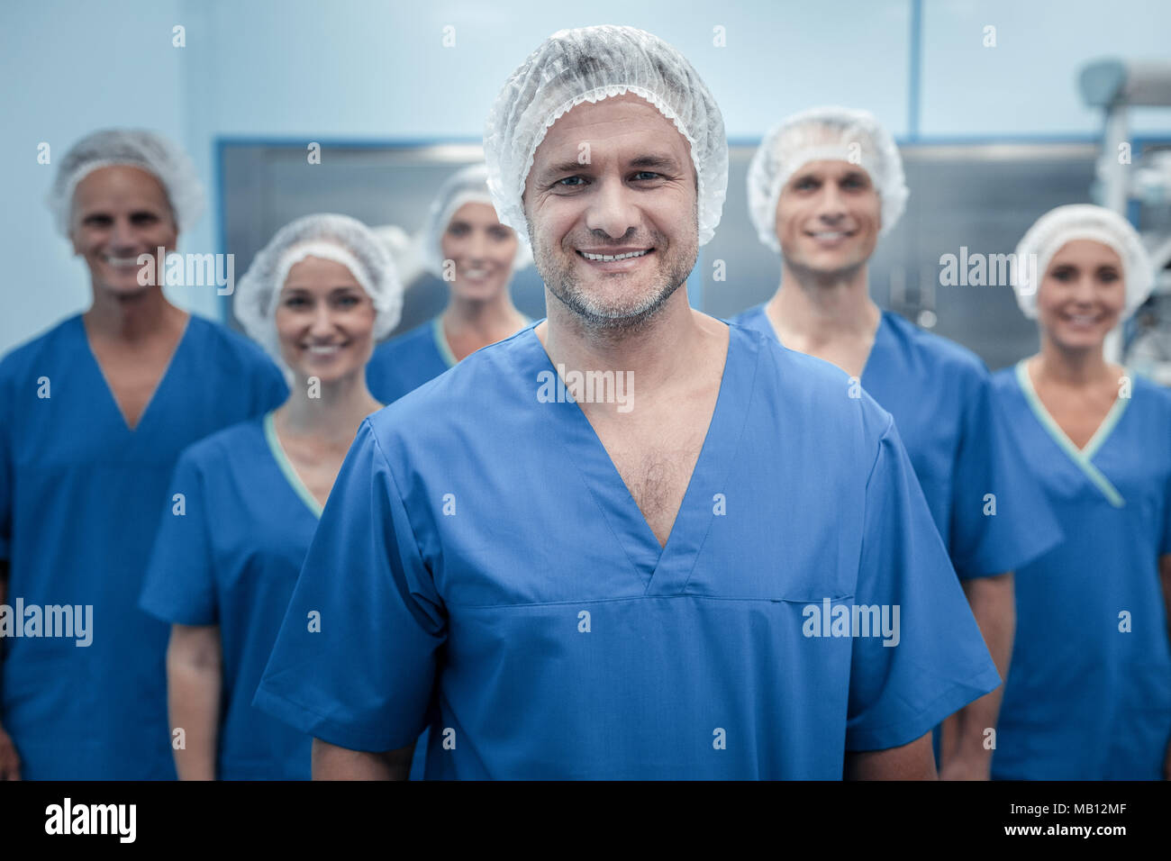 Smart chirurgien expérimenté debout devant son équipe Banque D'Images