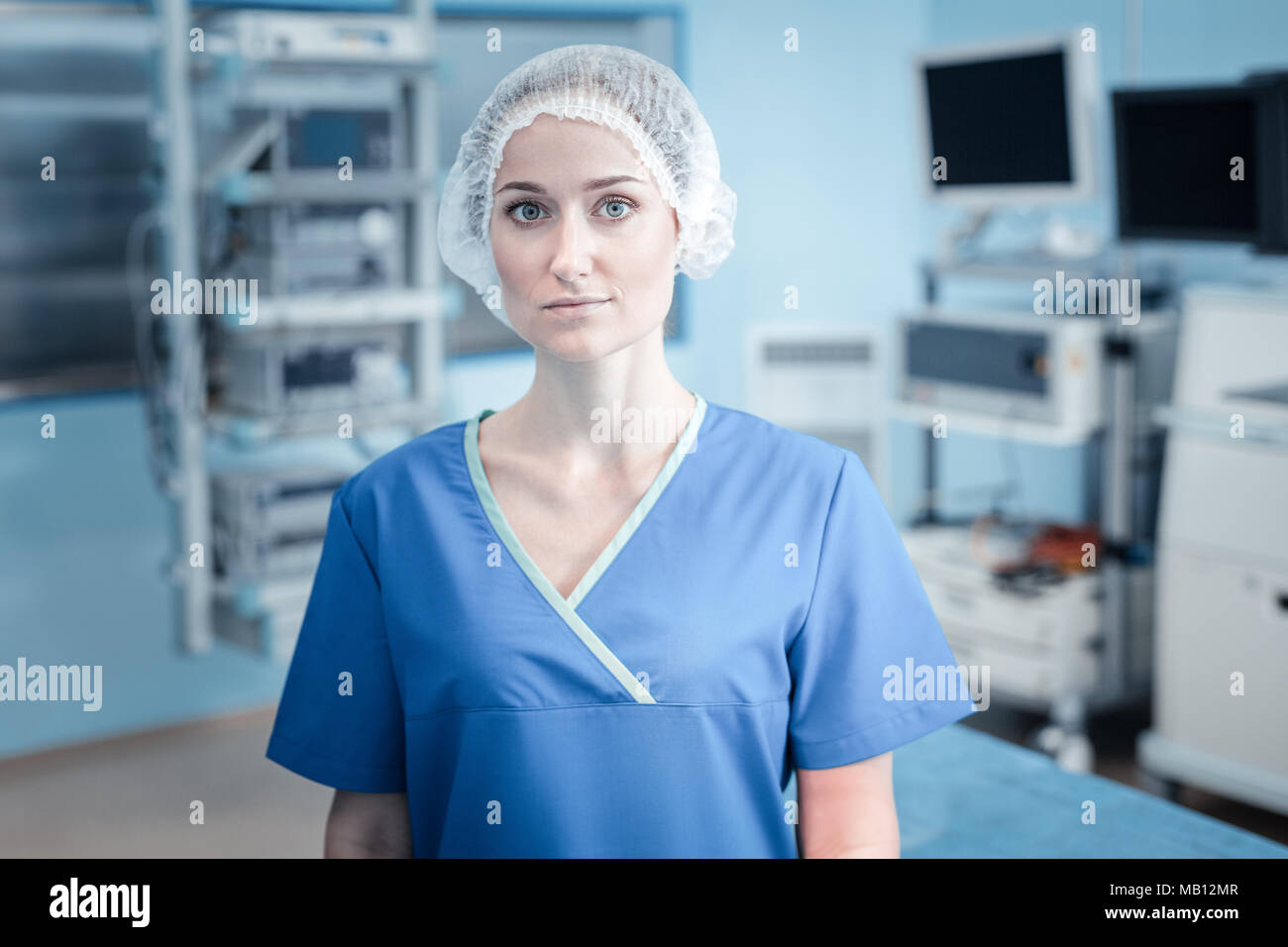 Surgeon standing professionnel sérieux dans la salle d'opération Banque D'Images