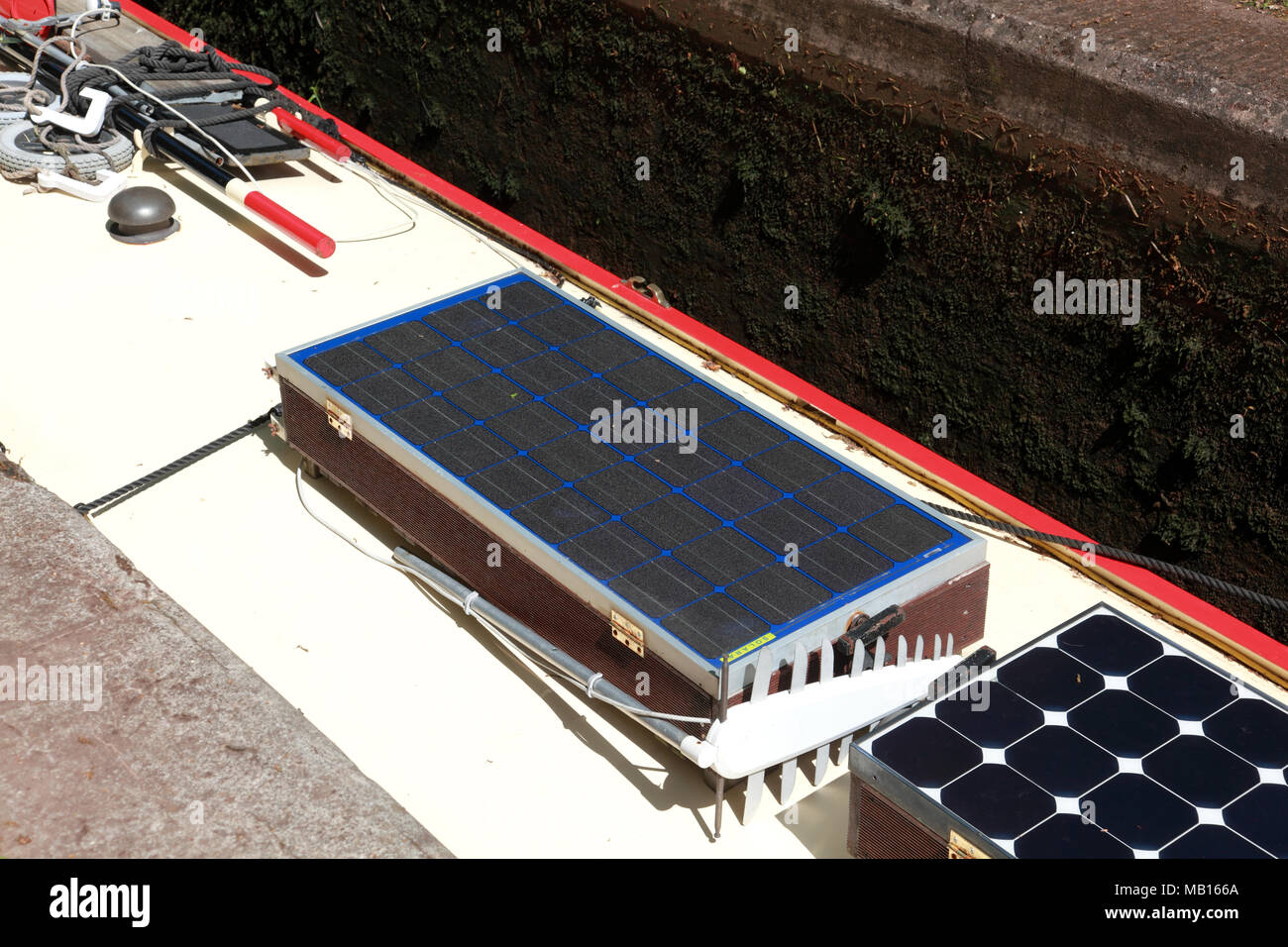 Des panneaux solaires sur le toit d'un grand classique dans une écluse du canal Banque D'Images Des panneaux solaires sur le toit d'un grand classique dans une écluse du canal Banque D'Images