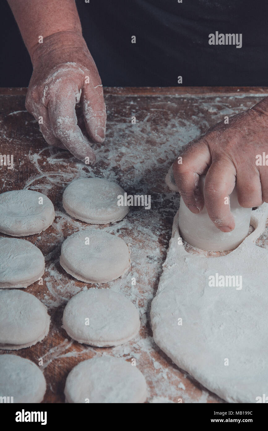 Granny serre un verre d'un cercle dans une pâte sur la table 2018 Banque D'Images