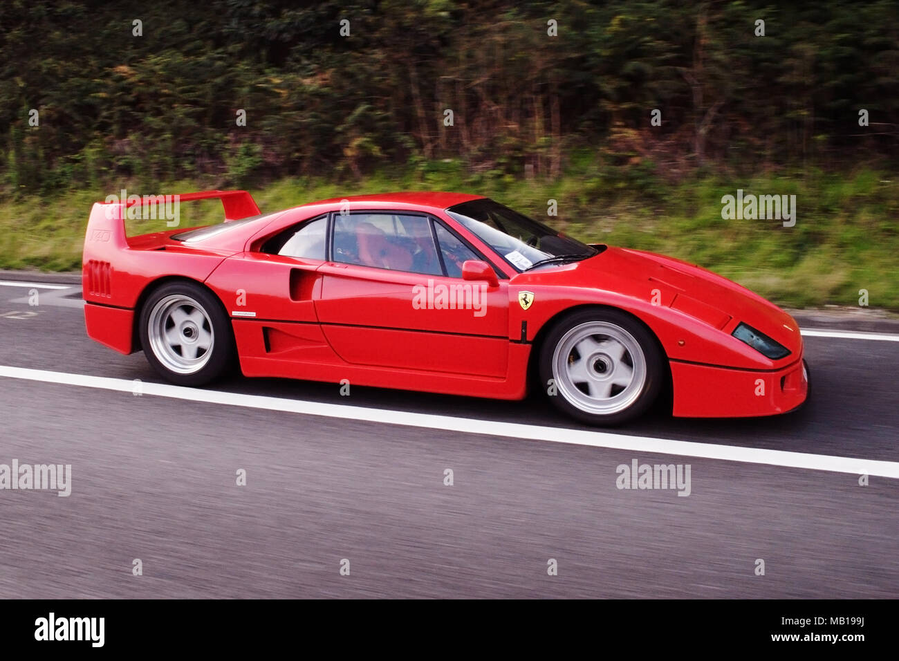 Modern classic rouge Ferrari F40 la conduite sur la voie publique. Banque D'Images