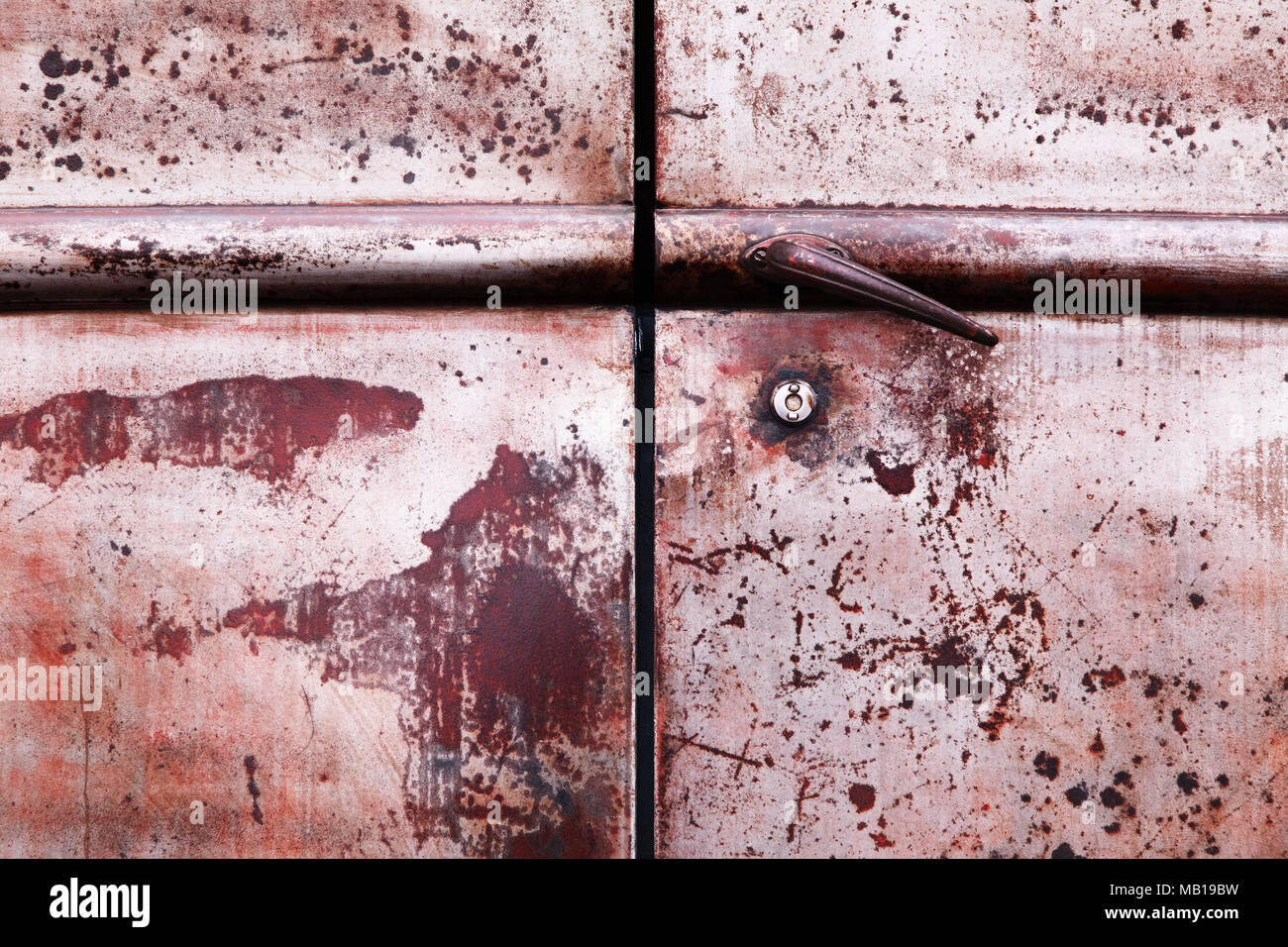 Belles portes en acier industriel corrodées et rouillées. Texture et textures rouillées marron et rouge avec poignée et serrure. Banque D'Images