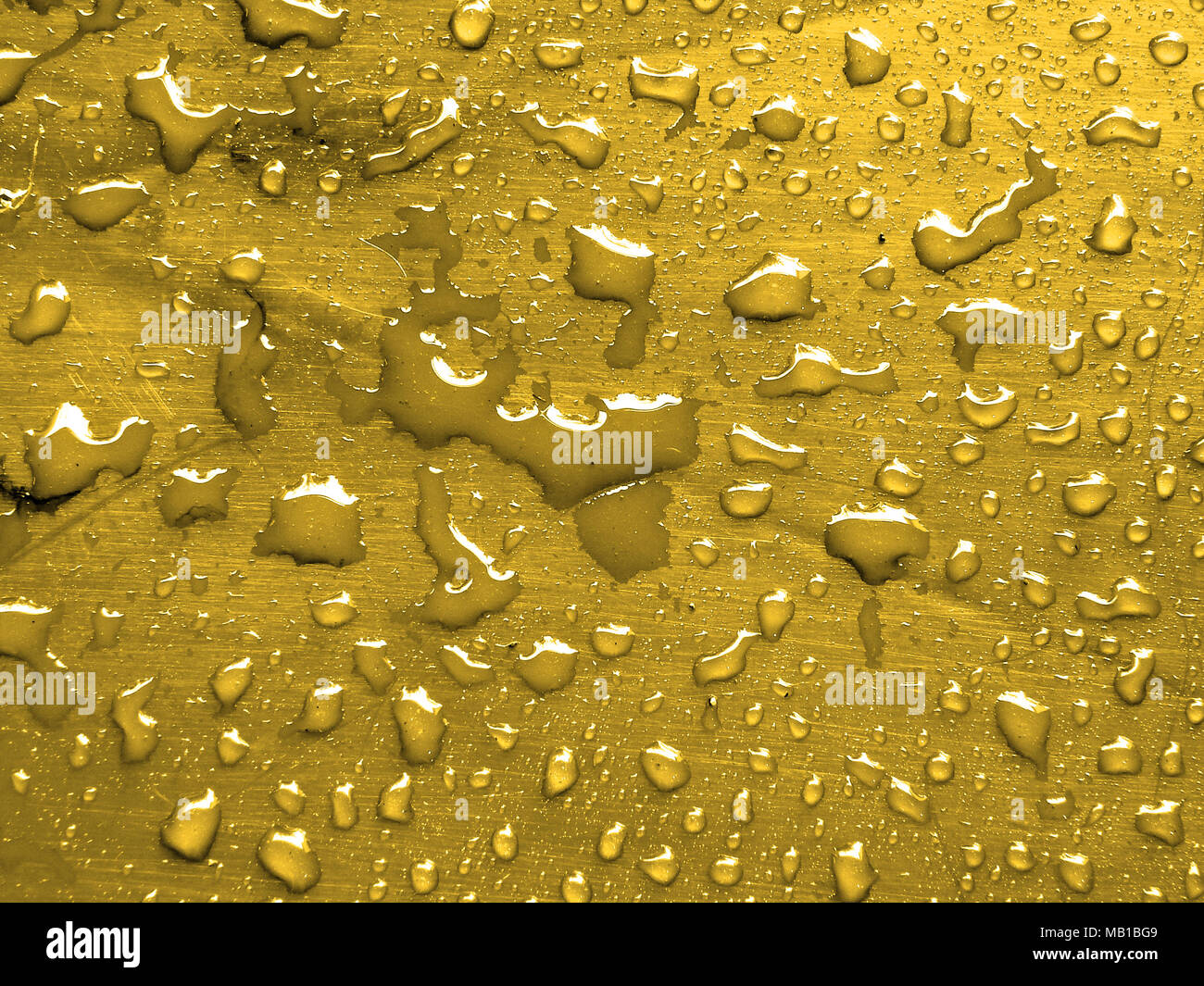Goutte d'eau sur une surface métallique d'or Banque D'Images